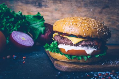 Ev yapımı Burger (cheeseburger) ahşap bir arka planda sığır eti ile