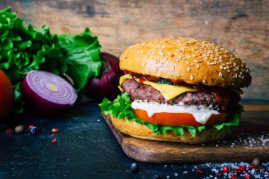 Ev yapımı Burger (cheeseburger) ahşap bir arka planda sığır eti ile