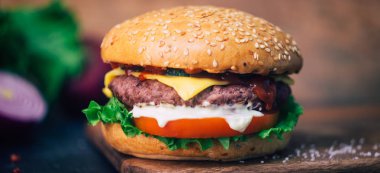 Ev yapımı Burger (cheeseburger) ahşap bir arka planda sığır eti ile