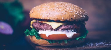 Ev yapımı Burger (cheeseburger) ahşap bir arka planda sığır eti ile