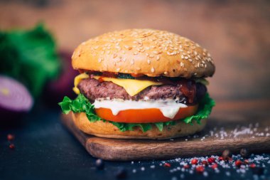 Ev yapımı Burger (cheeseburger) ahşap bir arka planda sığır eti ile