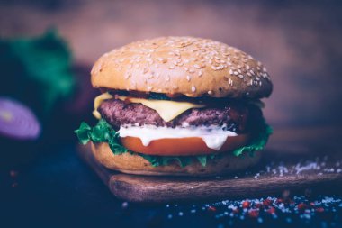 Ev yapımı Burger (cheeseburger) ahşap bir arka planda sığır eti ile