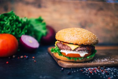 Ev yapımı Burger (cheeseburger) ahşap bir arka planda sığır eti ile