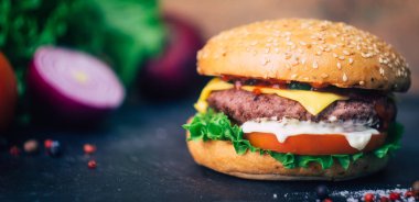 Ev yapımı Burger (cheeseburger) ahşap bir arka planda sığır eti ile