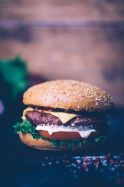 Ev yapımı Burger (cheeseburger) ahşap bir arka planda sığır eti ile