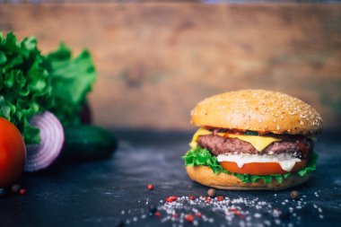 Ev yapımı Burger (cheeseburger) ahşap bir arka planda sığır eti ile