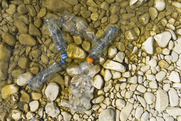 Plastic pollution in water. Dirty plastic bottles in a river. Po