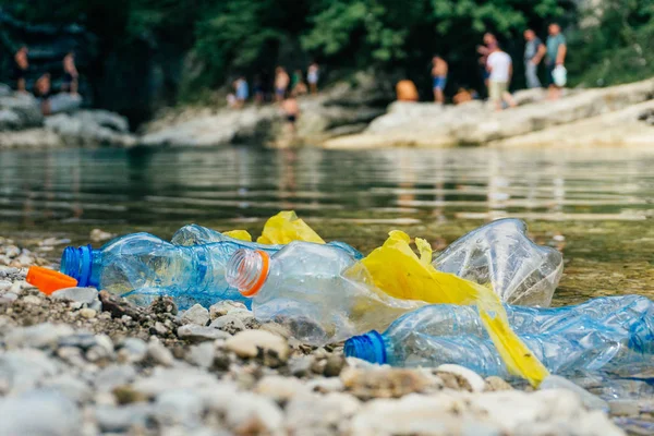 Nehirde Plastik Kirliliği. Kirli plastik şişe ve çanta o