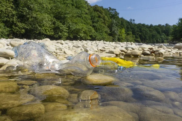 Plastic pollution in water. Dirty plastic bottles in a river. Po