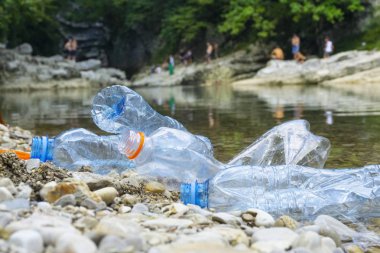 Sudaki plastik kirliliği. Nehirde kirli plastik şişeler. Po