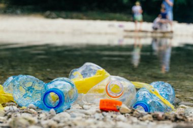 Nehirde Plastik Kirliliği. Kirli plastik şişe ve çanta o