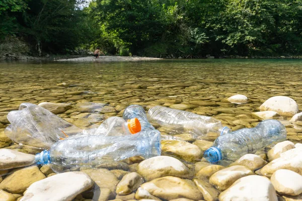 川のプラスチック汚染。汚れたペットボトルとバッグ o — ストック写真