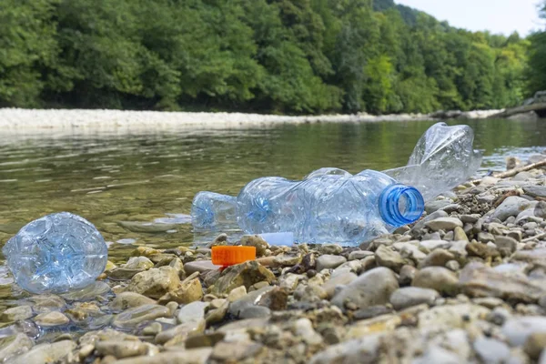 Plastic pollution in water. Dirty plastic bottles in a river. Po