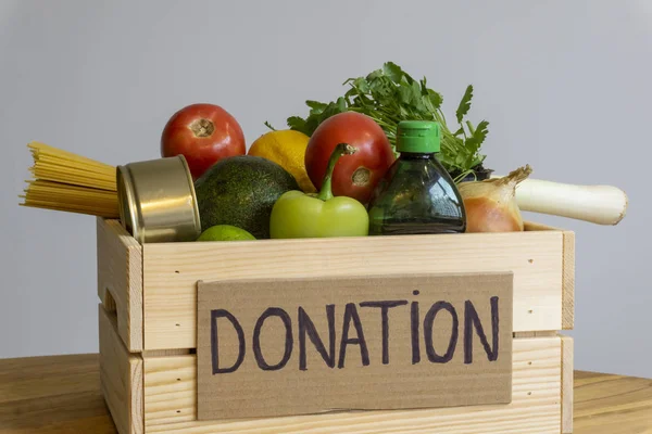 Concepto de donación de alimentos. Caja de donaciones con verduras, frutas y — Foto de Stock