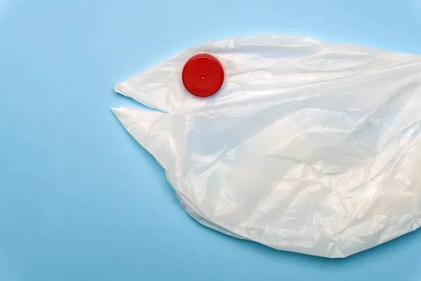 A plastic bag in the shape of a sea fish on a blue background.
