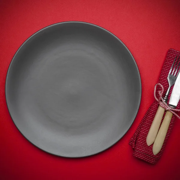 Empty plate on a red background (table) with a knife and fork. F — Stock Photo, Image