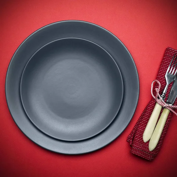 Empty plate on a red background (table) with a knife and fork. F — Stock Photo, Image