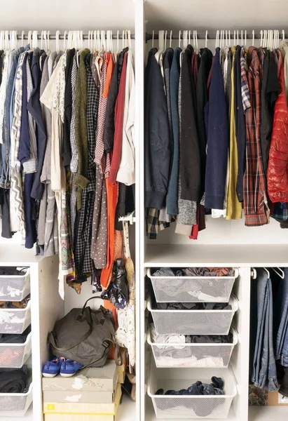 Colored clothes in the closet. Storage of clothes and things in