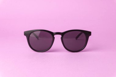 Saf pembe arka planda pembe güneş gözlükleri.