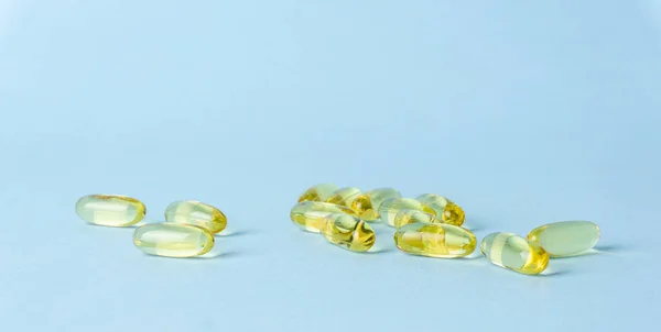 Fish oil (fish fat) capsules. Omega 3 vitamins in yellow gelatin