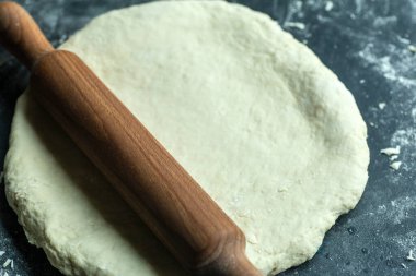 Hamur pizzası arka planı. Mutfak masasında pizza hamuru ya da ekmek pişirmek. Gıda arkaplanı