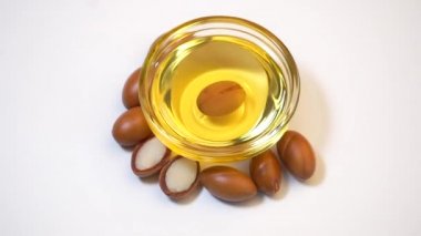 Beyaz arka planda Argan tohumları ve yağı. Argan yağı bazlı kozmetik konsepti.