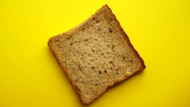烤面包在黄色的背景上旋转 由黑麦面粉和谷类制成 最低限度食物概念 — 图库视频影像