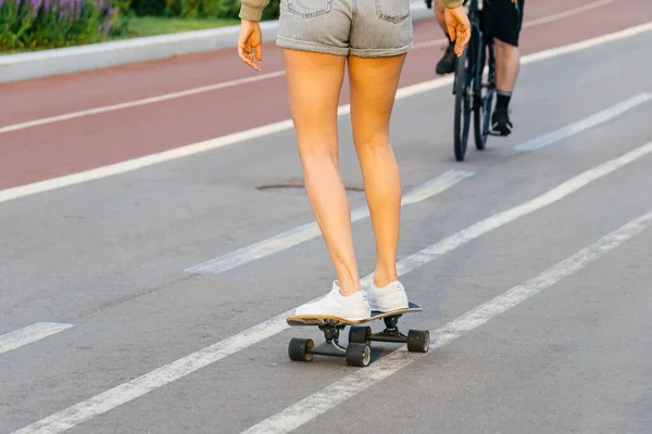 城市里穿着短裤坐在滑板上的小女孩 夏天在城里休息和放松一下 生活方式概念 — 图库照片