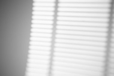 Güneşli bir havada, pencerenin gölgesi beyaz bir duvarda, parlak bir ışıkla. Fotoğraf için gölge örtüsü efekti.