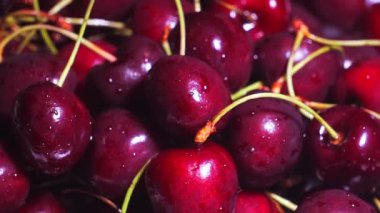 Kiraz yakın çekim. Tatlı kiraz su damlalarıyla dolu bir tabakta dönüyor..
