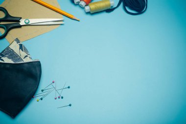 Yüz maskesi boyama ve ev yapımı maske konsepti. Evde renkli kumaştan özel bir antibakteriyel yüz maskesi dikmek