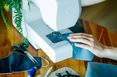 Yüz maskesi boyama ve ev yapımı maske konsepti. Evde renkli kumaştan özel bir antibakteriyel yüz maskesi dikmek