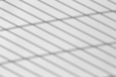 Fotoğraf için gölge örtüsü efekti. Şebeke çizgilerinin gölgeleri ya da güneşli bir günde beyaz bir duvarda parmaklıkların rendelenmesi. Geometrik gölgeler