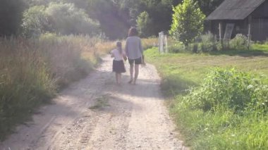 Anne ve bebek yaz akşamlarında kırsal köy yolunda birlikte yürür ve yürür. Anne ve kızı birlikte vakit geçiriyorlar.