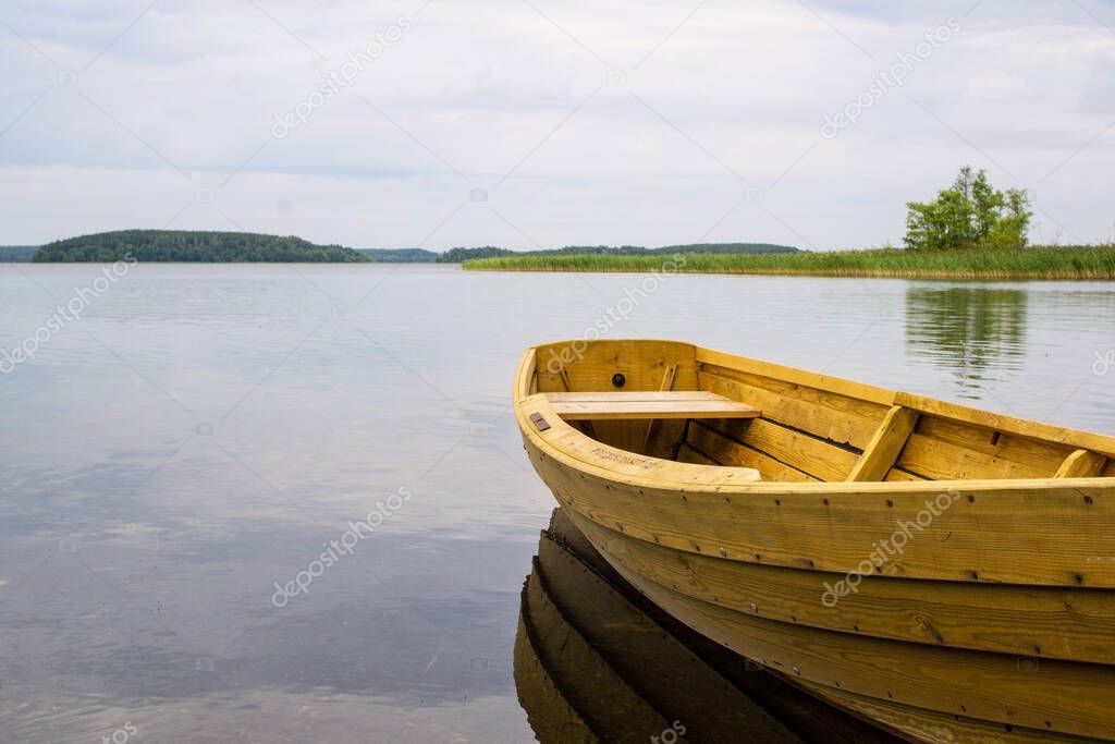 Boat on the lake. Wooden boat on a calm summer lake or river in summer. Zen nature background.