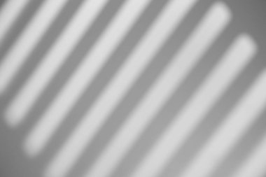 Gölge örtüsü etkisi. Pencere çerçevelerinin gölgeleri, gün ışığında duvardaki parmaklıklar ve çizgiler. Yumuşak güneş ışığı