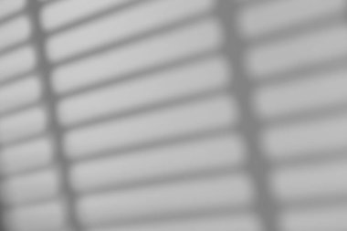 Gölge örtüsü etkisi. Pencere çerçevelerinin gölgeleri, gün ışığında duvardaki parmaklıklar ve çizgiler. Yumuşak güneş ışığı