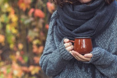 Sonbahar parkında kadınların elinde bir fincan kahve ya da çay. Sonbahar havası, rahat, aşk ve romantizm konsepti. Boşluğu kopyala