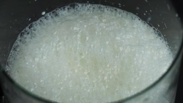 Mousse de lait et bulles d'air sur la surface du lait lorsqu'il est fouetté. Lait de vache frais — Video