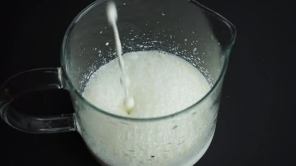 Melk gieten in een glas op een donkere achtergrond. Melk en zuivelproducten. — Stockvideo