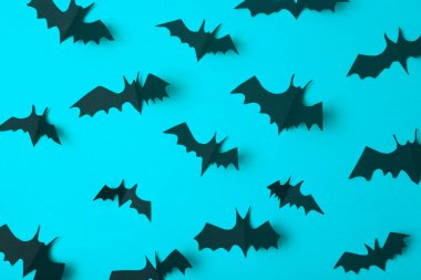 Cadılar Bayramı geçmişi. Mavi arka planda kağıttan kesilmiş siyah yarasalar. Bayram için Cadılar Bayramı dekorasyonu ve süslemeleri, kopya alanı.