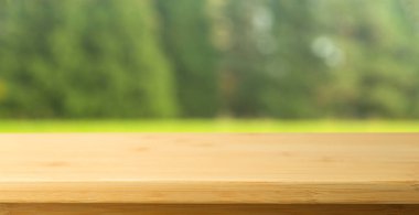 Doğa masası arka planı. Yazın arka planında boş ahşap masa güneşli doğa, çimen ve orman.