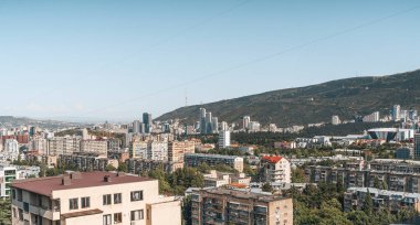Gürcistan 'ın Tiflis kentinin panoramik manzarası, yukarıdan ele geçirildi. Görüntü, eski Sovyet döneminden kalma panel konutlarla şehir evriminin altını çizen yeni yerleşim yerlerindeki yüksek binalar arasında çelişiyor.