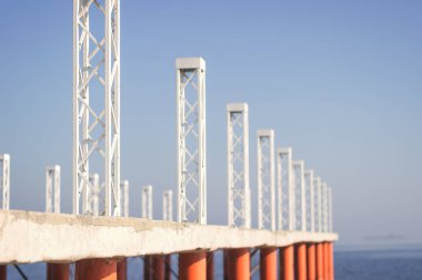 Beyaz ve turuncu renk sütunlarının ile Pier. mavi gökyüzü arka planı. ritim. manzara. çapraz