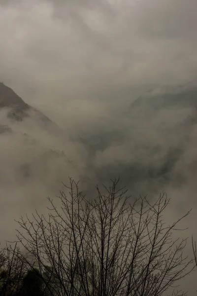 Nevoeiro e neve na montanha. Paisagem em estilo vintage — Fotografia de Stock