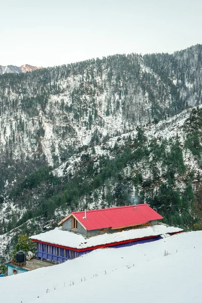 Casa in legno innevata in montagna - paesaggio invernale maestoso in himalaya — Foto Stock