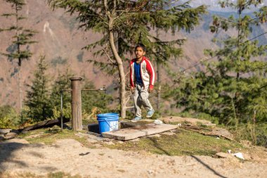 Kullu, Himachal Pradesh, Hindistan - 09 Aralık 2018 : Dağlarda musluk suyundan yüzünü yıkayan bir çocuk -