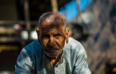 Kullu, Himachal Pradesh, India - January 17, 2019 : Portrait of old man in mountain, Himalayan people - clipart