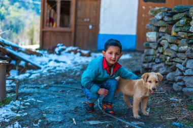 Kullu, Himachal Pradesh, Hindistan - 26 Ocak 2019 : Dağlarda köpekle oynayan mutlu çocuk
