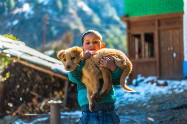 Kullu, Himachal Pradesh, Hindistan - 26 Ocak 2019 : Dağlarda köpekle oynayan mutlu çocuk